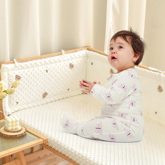 bebe tout heureux avec tour de lit bebe
